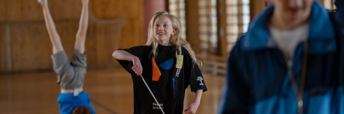 Children having fun in a school gym, with gymnastics and playful activities.